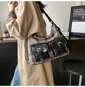 Detail of vintage brown plaid tweed shoulder bag with black leather pockets and gold buckles