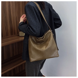 Detail view of olive brown retro hobo tote bag with vintage leather texture on model
