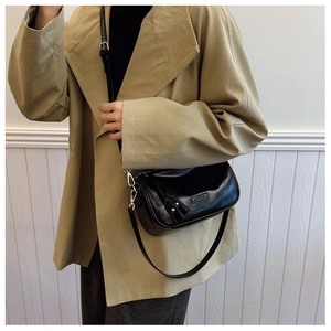 Détail du sac cylindre en cuir ciré noir avec crochets en métal argenté