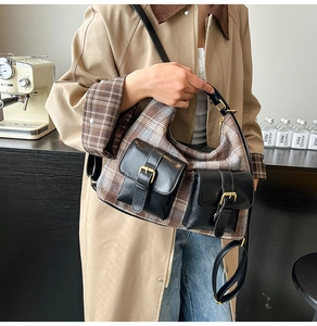 Detail view of a vintage plaid shoulder bag with leather pockets and metal buckles