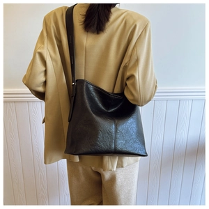 Detailed view of the vintage textured black PU leather surface on a large tote bag