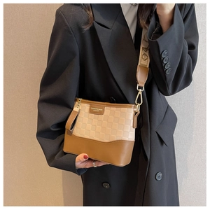 Close-up of beige checkerboard crossbody bag with elegant wide woven jacquard strap