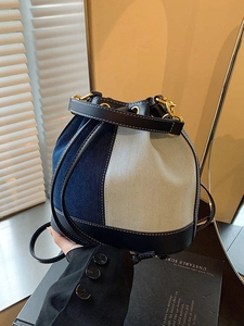 Denim patchwork bucket bag with black leather trim and drawstring closure for women