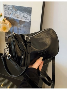 Sac bandoulière cylindrique noir brillant avec fermeture éclair argentée et sangle réglable