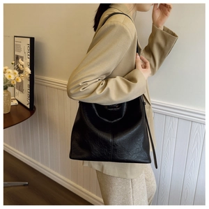 Close-up of a large black bucket bag showing the high-quality lychee grain leather texture