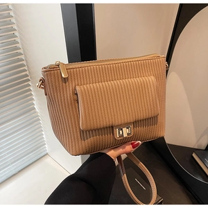 Close-up of camel brown handbag featuring vertical stripes texture and gold twist lock