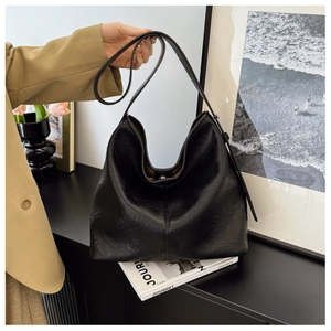 Close-up of black PU leather hobo bag with natural textures and adjustable shoulder strap