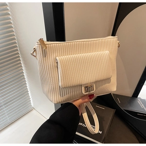 Detail of off-white corduroy shoulder bag with vertical stripes and metal buckle pocket