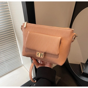 Detail view of pink quilted handbag showing vertical corduroy texture and golden square lock