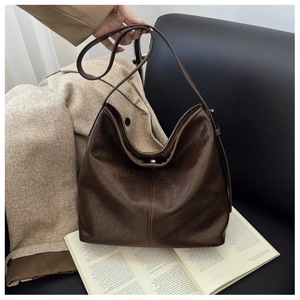 Detail view of large dark brown tote bag with vintage oil wax leather and button closure