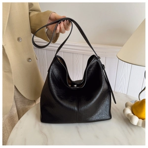 Detail of black large capacity hobo bag with textured soft leather and wide strap