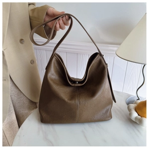 Detail of deep brown large hobo bag showing pebbled leather texture and crossbody strap