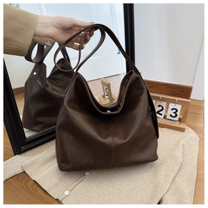 Close-up of a large brown hobo bag with lychee texture and vertical stitching detail