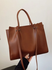 Minimalist large brown tote bag in matte faux leather with top handles and shoulder strap