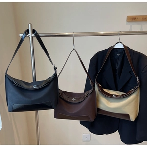 Detailed close-up of vintage tote bags in black, coffee, and beige with metal twist locks