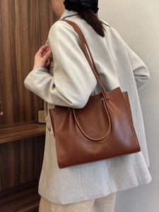 Brown leather tote bag for women showing a minimalist rectangular design with dual handles