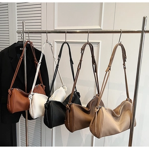 Detailed view of large crescent shoulder bags in five colors with vertical pleated texture