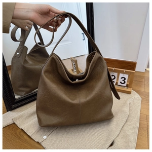 Detail of vintage brown leather hobo bag with wide strap and vertical stitching accents