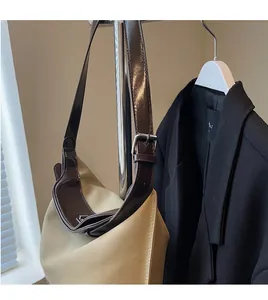 Detail of adjustable leather strap with metal buckle on contrast canvas tote bag