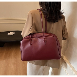 Borsa tote bordeaux in pelle martellata indossata a spalla in un interno elegante