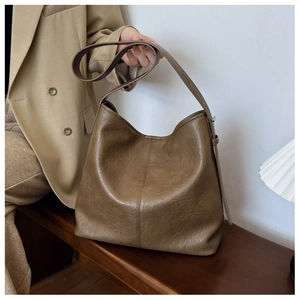 Detail view of large coffee brown bucket bag with adjustable wide strap for women