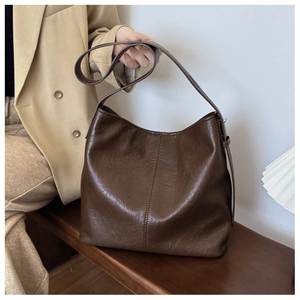 Close-up of brown vintage Hobo bag showing faux leather texture and vertical stitching detail