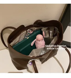 Detailed view of spacious interior of a brown tote bag with various daily essentials