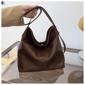 Close-up of the pebbled texture and slouchy design on a large brown hobo shoulder bag