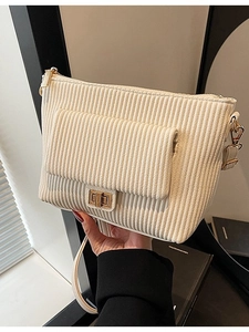 Cream-white corduroy crossbody bag with vertical textures and a gold twist-lock closure