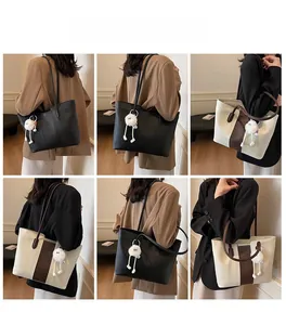 Macro detail of large tote bags in black and beige faux leather with plush charm