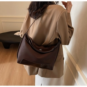 Detail view of large dark brown tote bag with glossy leather拼接and metallic lock buckle
