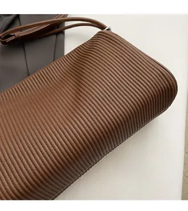 Detailed macro view of the brown pleated leather texture and soft material on the tote bag