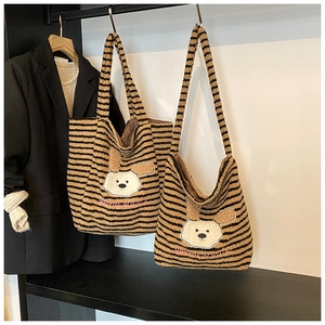 Detail einer gestreiften Plüschtasche mit süßem Cartoon-Tier-Aufnäher und rosa Stickerei