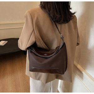 Detail of a dark brown large hobo bag with adjustable strap and silver metal buckle