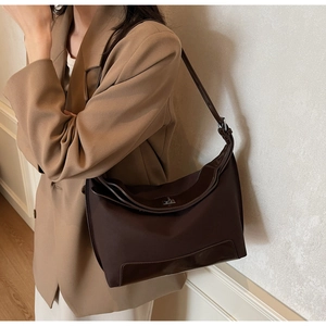 Detail of adjustable leather strap and silver metal clasp on minimalist coffee canvas tote