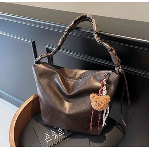 Close-up of vintage brown large capacity shoulder bag with unique pleated strap detail