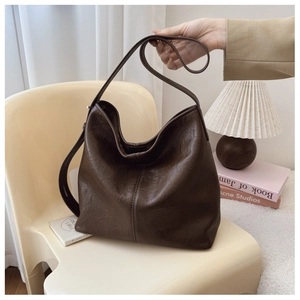 Detail view of large dark brown hobo bag with grainy faux leather texture and stitching