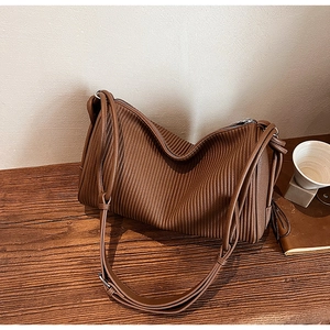Detail showing the brown pleated texture and silver zipper of this retro shoulder bag