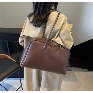 Vista posteriore di una borsa tote in pelle marrone minimalista con trama martellata