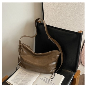 Detail of vintage brown leather hobo bag with knotted zipper and glossy finish