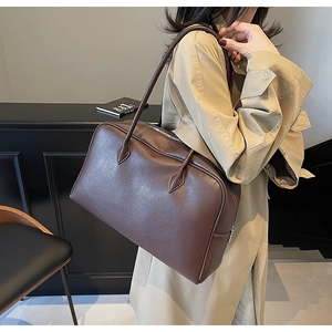 Dettaglio della borsa a spalla in pelle martellata marrone scuro con cerniera argentata