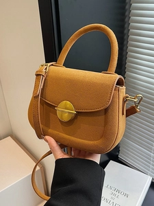 Retro mustard yellow suede saddle bag with gold metal clasp and adjustable strap