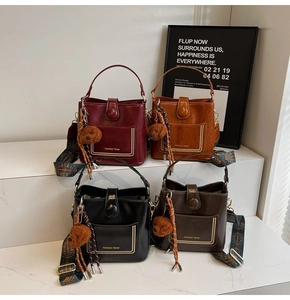 Detailansicht bunter Beuteltaschen mit Webriemen und Plüschbär-Anhängern