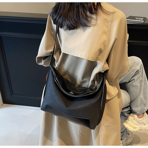 Detail of black nylon tote bag with leather patchwork and smooth zipper on model