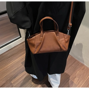 Macro detail of brown leather bag showing premium stitching and silver hardware accents