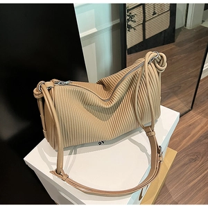 Close-up of khaki pleated leather shoulder bag featuring fine accordion texture and silver zip