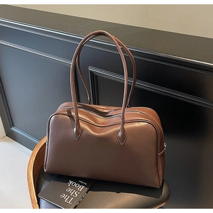 Dettaglio della borsa tote retrò in pelle marrone martellata su sedia di pelle