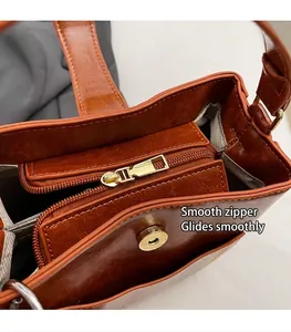 Detalle del interior del bolso bucket marrón con cremallera dorada y hebilla magnética
