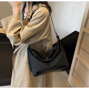 Detail of the black crescent shoulder bag featuring adjustable leather strap and silver metal buckle
