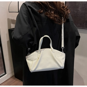 Detailed view of cream PU leather crossbody bag with pleated wave design on a model